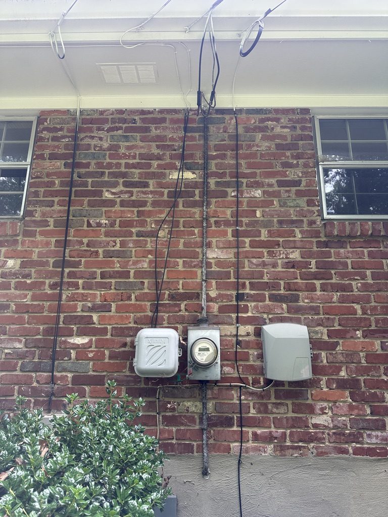 Before — old meter and service equipment on brick wall